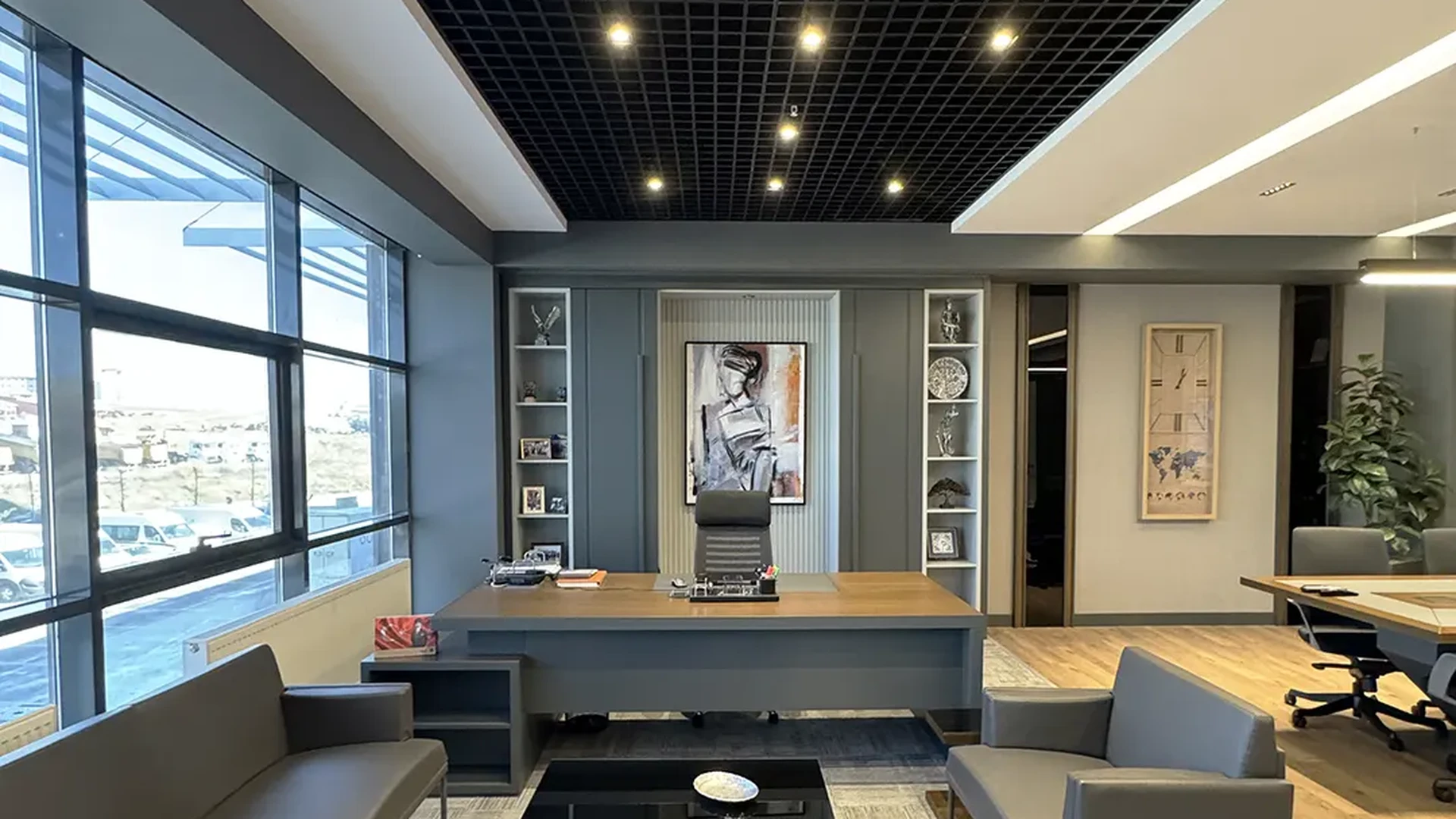 İlkiş Elektrik yönetici odası, meşe kaplama masa, gri oturma grubu, siyah grid tavan, kitaplık ve tablo detayı, Ruler İç Mimarlık Ankara