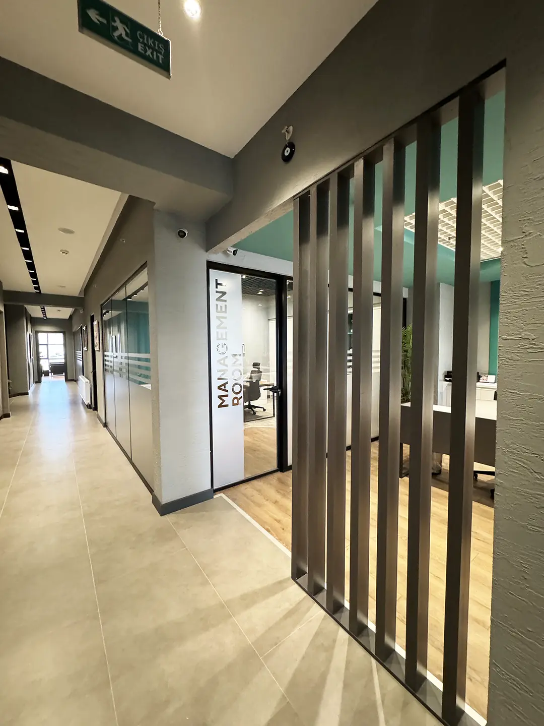 İlkiş Elektrik ofis koridor genel görünüm, lineer aydınlatma ve gri tonlarda duvar kaplaması