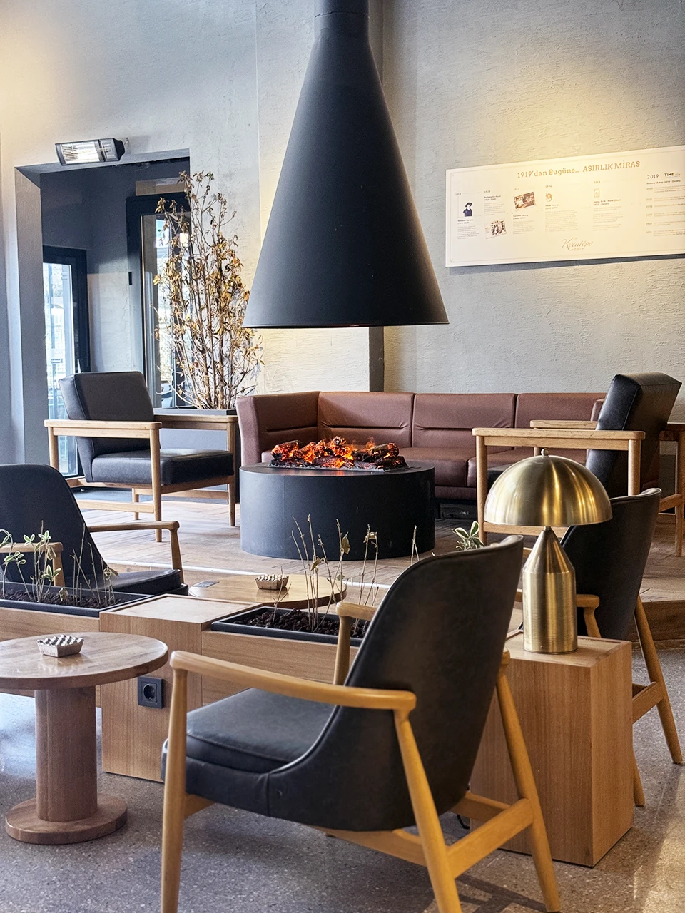 Kafe şömineli oturma alanı — yuvarlak şömine ve İskandinav etkili tasarım