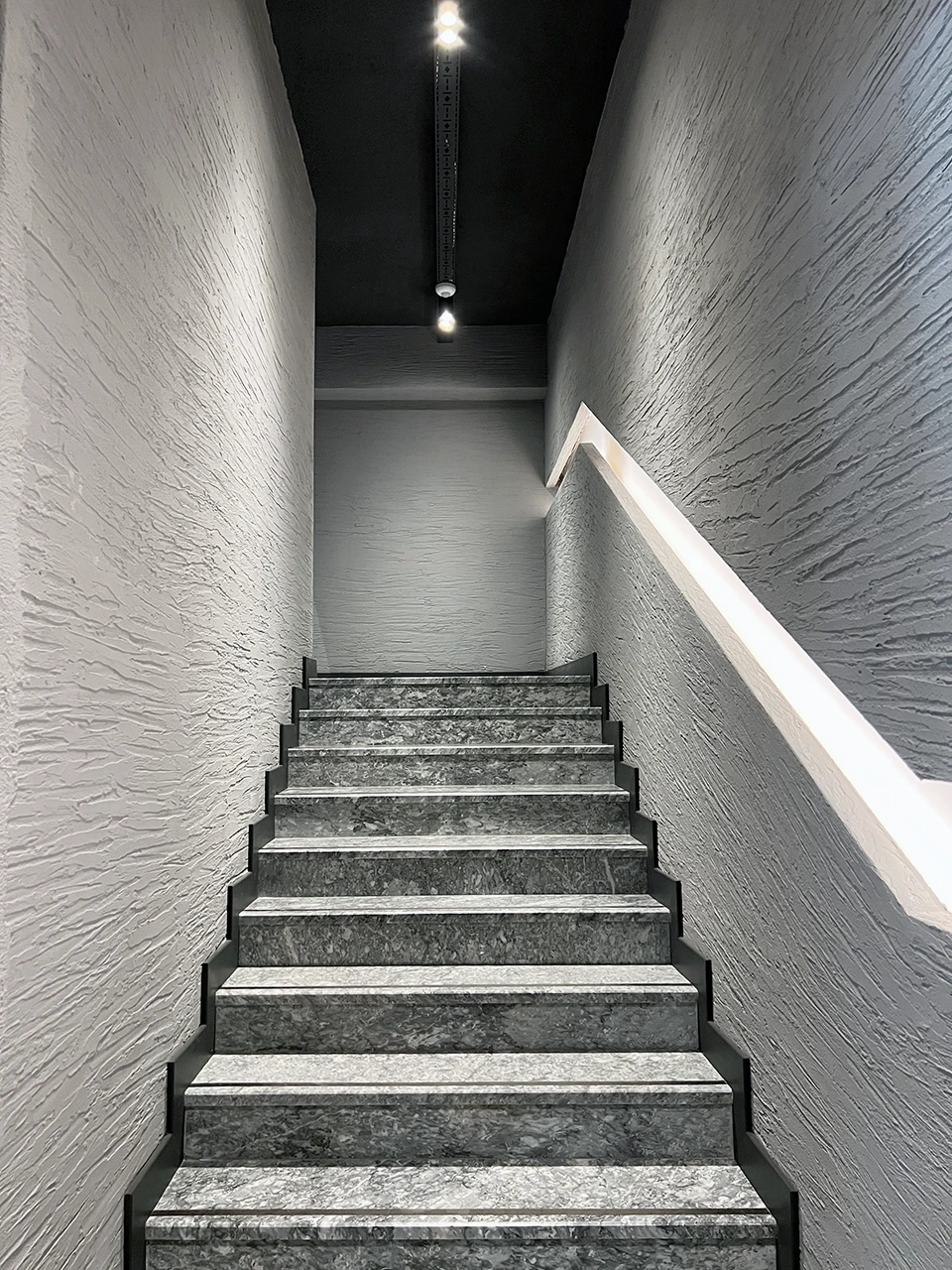 Ofis merdiven tasarımı — doğal taş basamaklar ve dokulu duvar kaplaması