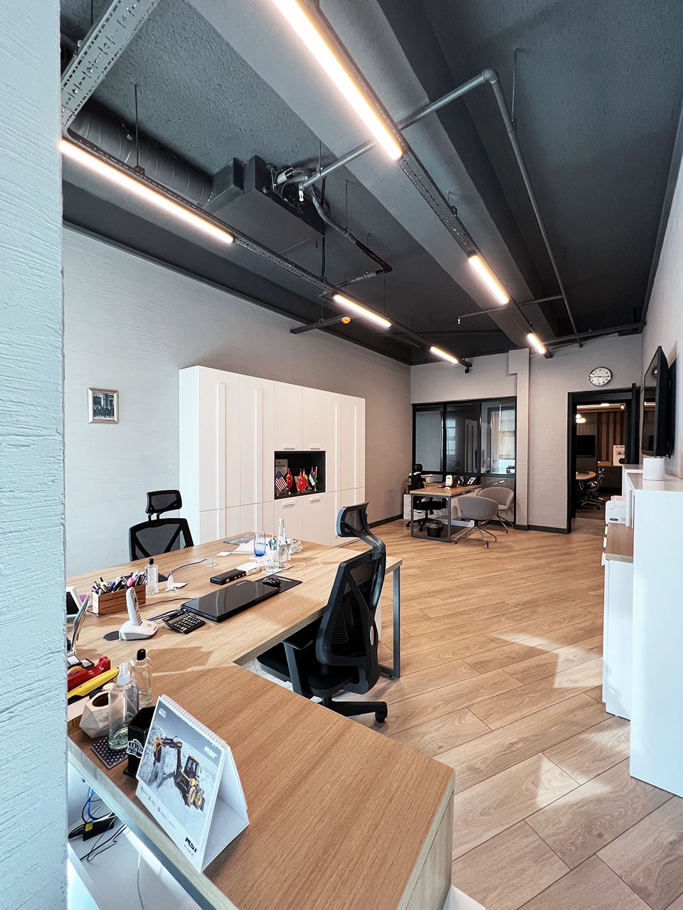 Açık ofis çalışma alanı — endüstriyel tavan ve doğal ahşap zeminler