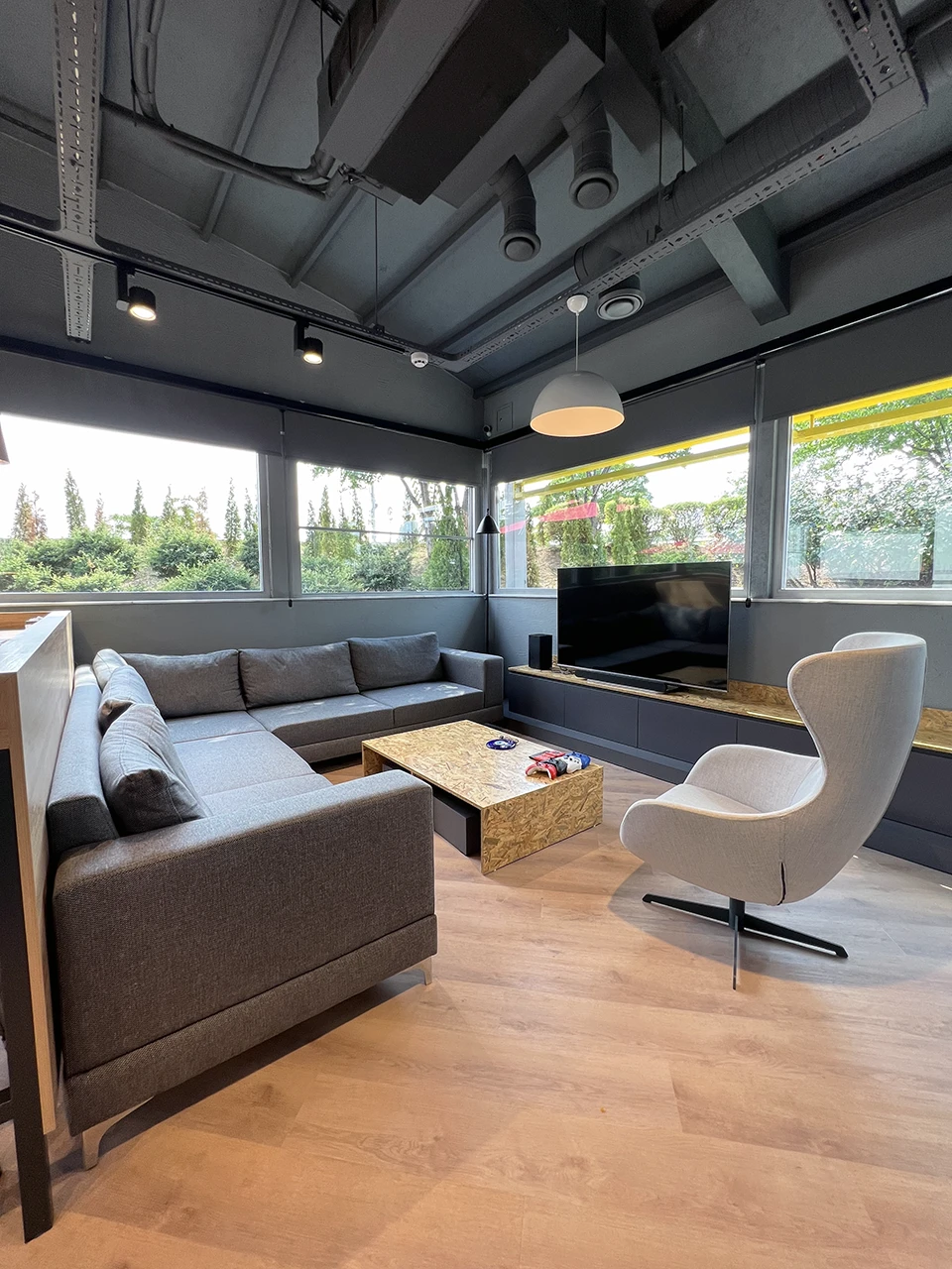 Panteon Ofis dinlenme ve lounge alanı, L koltuk, OSB sehpa, egg chair, TV ünitesi ve bahçe manzaralı panoramik pencere