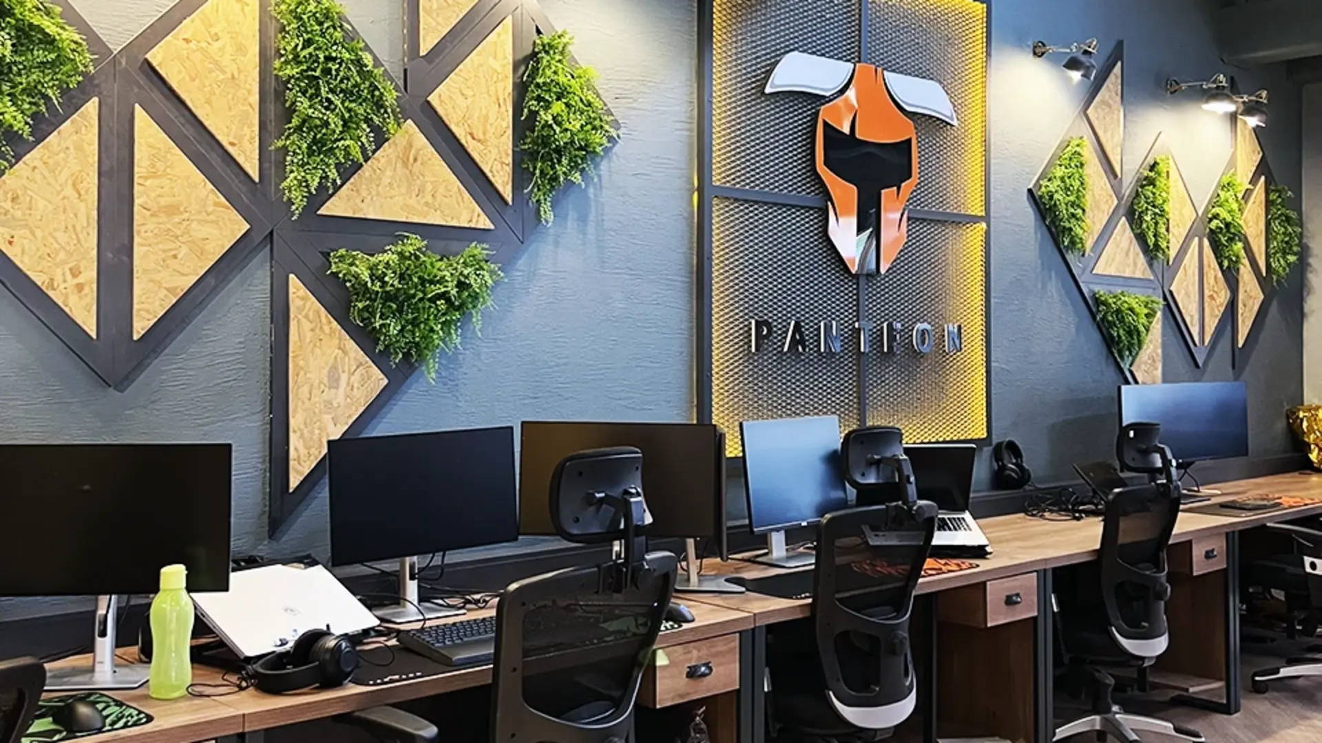 Panteon Ofis açık ofis duvar konsepti, OSB panel üçgen kompozisyon, yeşil duvar ve ışıklı Panteon logosu, Ruler İç Mimarlık Ankara